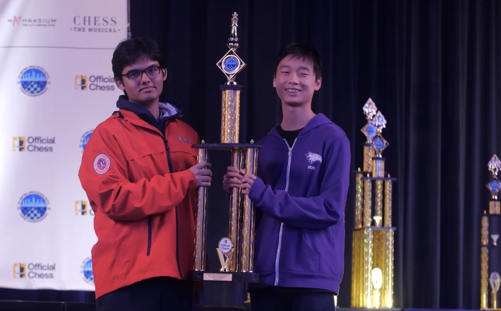 Two players holding a championship trophy