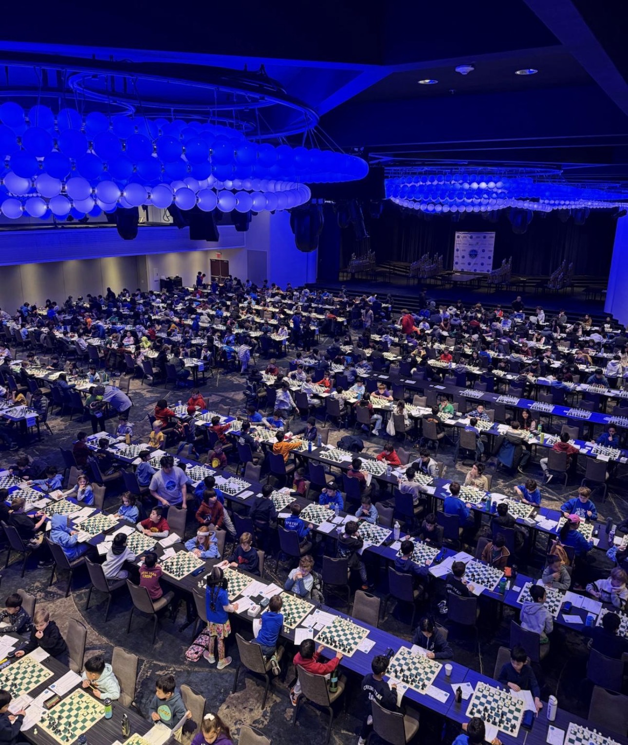 Players filling the ballroom under blue lights